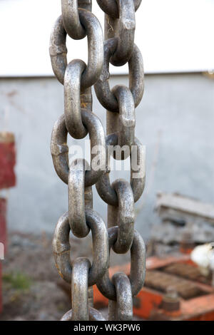 Dettaglio verticale colpo di catena pesante link su un sito in costruzione. Foto Stock