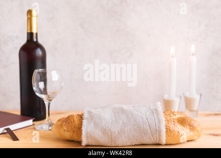 Lo shabbat o Shabath concetto. Challah pane e vino di shabbat, libro e candele, copia dello spazio. Tradizionale ebraica rito di Shabbat. Shabbat Shalom. Foto Stock