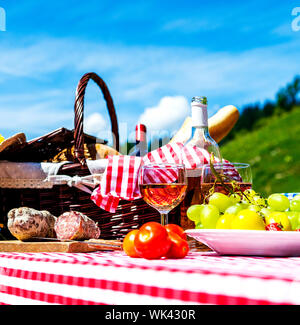 Assaggiato picnic sul prato vicino a un lago Foto Stock