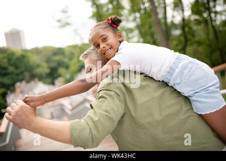 Allegro dark-eyed girl trascorrere il tempo con la sua amorevole papà Foto Stock