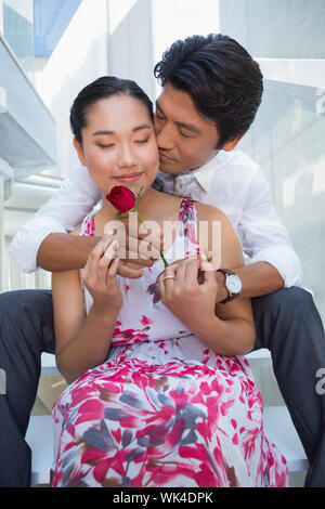 L'uomo che offre una rosa rossa alla ragazza su per le scale Foto Stock