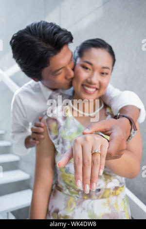 Giovane che mostra l'anello di innesto sul dito womans su per le scale Foto Stock