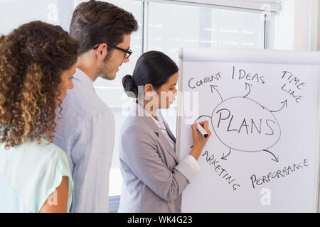 Casual imprenditrice dando una presentazione in ufficio Foto Stock