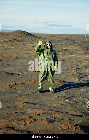 Strano scienziato in tute e maschere antigas nel deserto Foto Stock