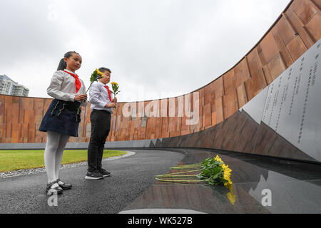 (190904) -- PECHINO, Sett. 4, 2019 (Xinhua) -- Gli studenti rappresentanti di fiori di laici per il massacro di Nanjing vittime presso il Memorial Hall di vittime in Nanjing massacro da invasori giapponesi in Nanjing East cinese della provincia di Jiangsu, Sett. 3, 2019. Le attività sono state tenutasi martedì in Nanjing per commemorare il 74º anniversario della vittoria del popolo cinese la guerra di resistenza contro l'Aggressione giapponese e il mondo Anti-Fascist guerra. (Xinhua/Li Bo) Foto Stock