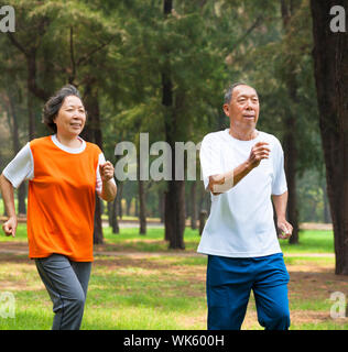 Felice coppia senior insieme per fare jogging nel parco Foto Stock