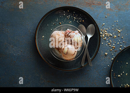 In casa gelato biologico scoop con il cioccolato e i dadi in una piastra da vicino Foto Stock