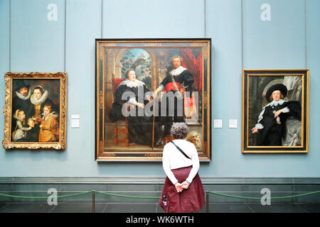 La donna in piedi di fronte a un lavoro del Barocco fiammingo pittore Jacob Jordaens presso la National Gallery, Trafalgar Square, London, Regno Unito Foto Stock