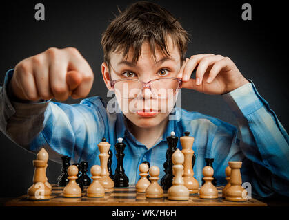 Wunderkind giocare a scacchi. Funny Nerd Ragazzo. Foto Stock