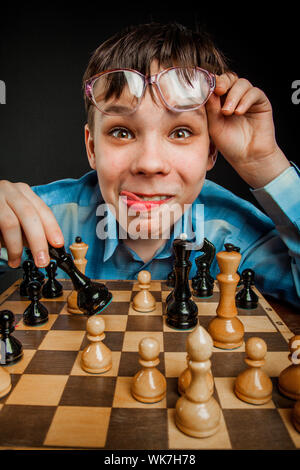 Wunderkind giocare a scacchi. Funny Nerd Ragazzo. Foto Stock