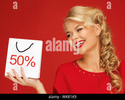 Bella donna in abito rosso con shopping bag Foto Stock