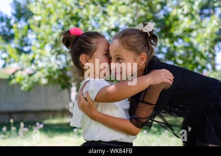 Due graziosi sorelle stanno abbracciando ogni altro all'aperto Foto Stock