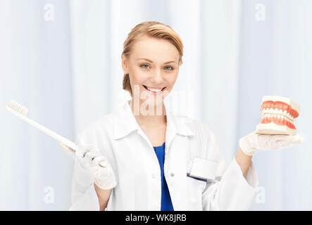 Foto di attraenti medico donna con spazzolino da denti e ganasce Foto Stock