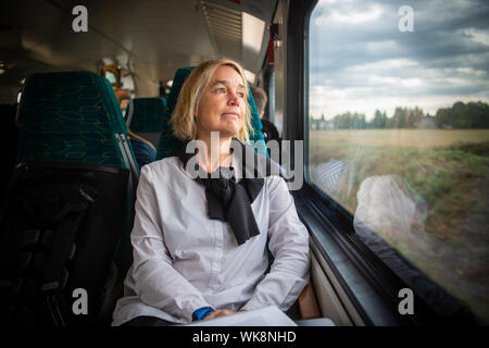 Cottbus, Germania. 20 agosto 2019. Christiane Hipp, facente funzione di presidente del Land di Brandeburgo l'Università Tecnica di Cottbus, siede in treno regionale e guarda fuori dalla finestra. Hipp commuta ogni giorno da Berlino al suo posto di lavoro. Credito: Arne Immanuel Bänsch/dpa/Alamy Live News Foto Stock