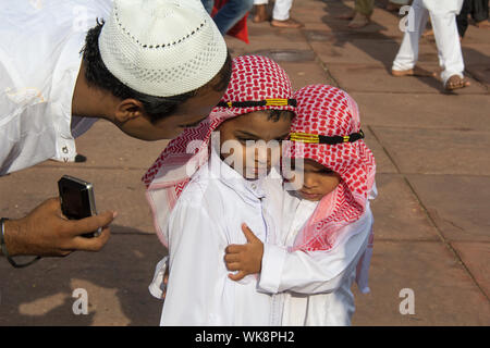 Padre che parla con i suoi figli in una moschea, Jama Masjid, Old Delhi, India Foto Stock