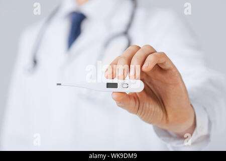 Medico maschio con termometro Foto Stock