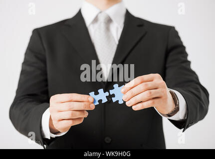 Close up di uomo che cerca di collegare i pezzi del puzzle. Foto Stock