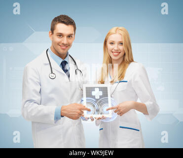 Due giovani medici puntando al tablet pc con app mediche Foto Stock