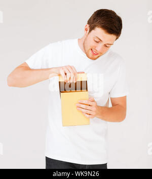 Uomo in bianco t-shirt con la confezione regalo Foto Stock