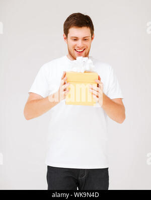 Uomo in bianco t-shirt con la confezione regalo Foto Stock