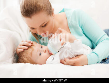 Madre felice e adorabile bambino con biberon Foto Stock