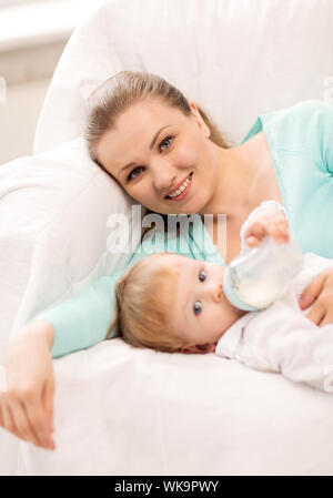 Madre felice e adorabile bambino con biberon Foto Stock