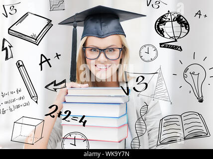L'istruzione e il concetto di università - happy studente nel tappo di graduazione con la pila di libri e scarabocchi Foto Stock