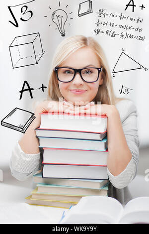 L'istruzione e il concetto di scuola - studente sorridente con la pila di libri e scarabocchi Foto Stock