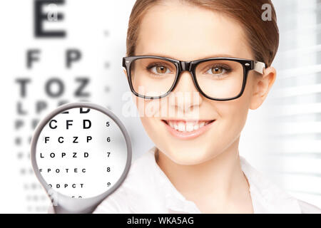 Medicina e vision concept - donna con lente di ingrandimento e grafico oculare Foto Stock