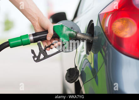 Il trasporto e il concetto di proprietà - uomo di pompaggio del carburante benzina in auto alla stazione di gas Foto Stock