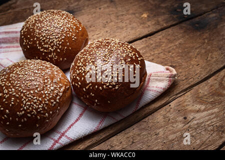 In casa del pane di pasta acida, round panini su vintage asciugatutto e sfondo di legno Foto Stock