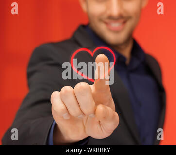 Bel uomo in tuta premendo il tasto virtuale Foto Stock