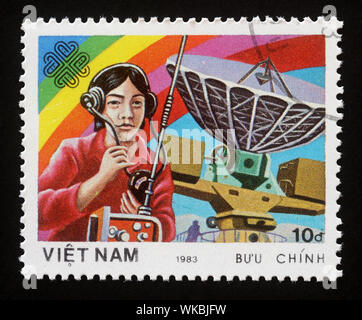 Timbro stampato in Vietnam mostra Radiooperator e antenna di comunicazione mondiale anno, circa 1983. Foto Stock