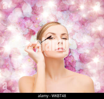 Cosmetici, salute e bellezza concetto - bella donna con mascara Foto Stock
