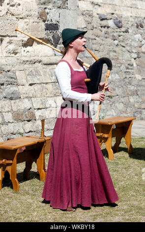 Donna in costume medievale suonare il baghèt a Dover Castle Foto Stock