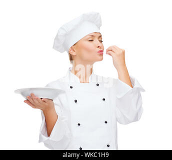 Lo chef femmina con placca con deliziosa segno Foto Stock