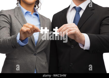 Il concetto di business - imprenditore e imprenditrice cercando di collegare i pezzi del puzzle in office Foto Stock