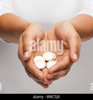 Womans mani a tazza che mostra delle monete in euro Foto Stock
