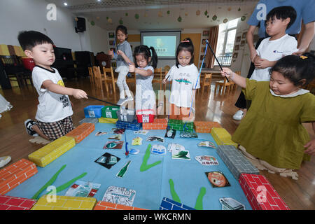 (190904) -- HUZHOU, Sett. 4, 2019 (Xinhua) -- Bambini giocare giochi divertenti per imparare l importanza di immondizia cernita presso una scuola materna di Huzhou, est della Cina di Provincia dello Zhejiang, Sett. 4, 2019. Gli insegnanti della scuola materna hanno organizzato varie attività come lo screening animazioni didattiche e giocare a giochi divertenti per aiutare gli studenti a imparare l importanza di immondizia cernita come il nuovo semestre ha iniziato a. (Xinhua/Xu Yu) Foto Stock