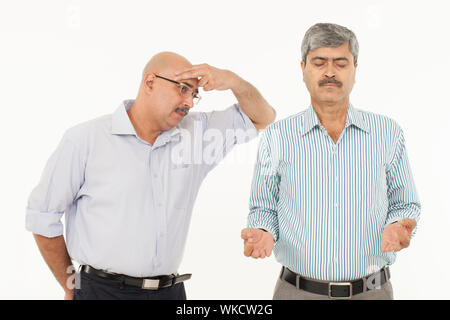 Uomo d'affari meditando accanto ad un uomo stressato Foto Stock