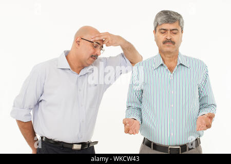 Uomo d'affari meditando accanto ad un uomo stressato Foto Stock