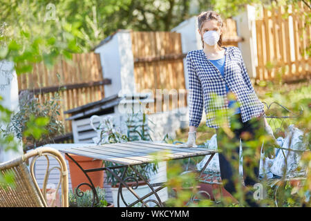 Giovane donna disimballaggio e appendere le foto su una parete in un nuovo appartamento Foto Stock