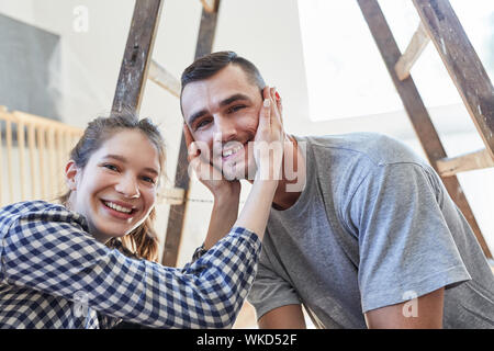 Giovane coppia felice è impaziente di rinnovamento nel nuovo appartamento comune Foto Stock