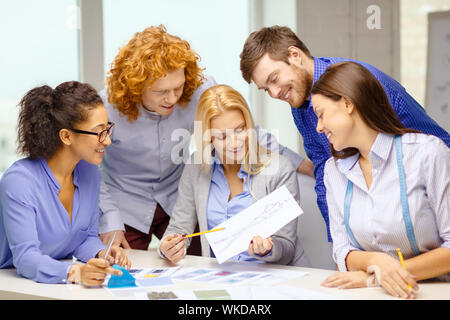 smiling creative team looking at sketch Foto Stock