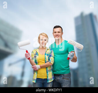 Sorridente paio di guanti con rulli di vernice Foto Stock