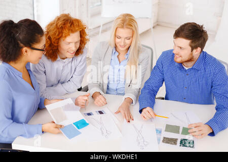 smiling creative team looking at sketch Foto Stock