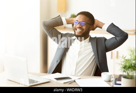 Imprenditore nero appoggiato in ufficio, Pendente ritornare in cattedra Foto Stock