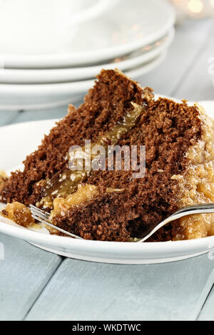 Una fetta di tedesco torta al cioccolato su una piastra. Profondità di campo con il fuoco selettivo su morso sulla forcella. Foto Stock