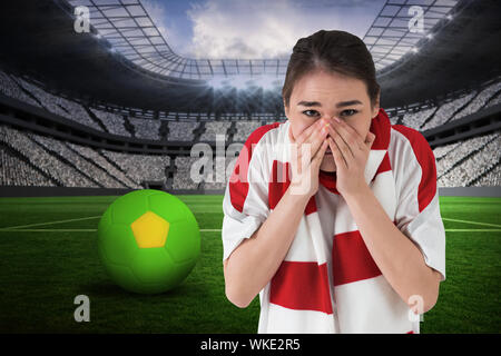 Sistema nervoso tifoso guardando avanti contro un enorme stadio di calcio con ventole in bianco Foto Stock