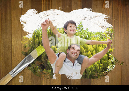Immagine composita del Padre e del figlio nel parco contro la superficie di legno con dei pennelli Foto Stock
